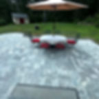 Stone patio with outdoor dining set and umbrella