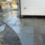 Stone patio installation next to white siding