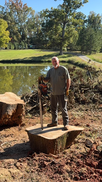 Owner of Southern Legacy Standing on tree stump
