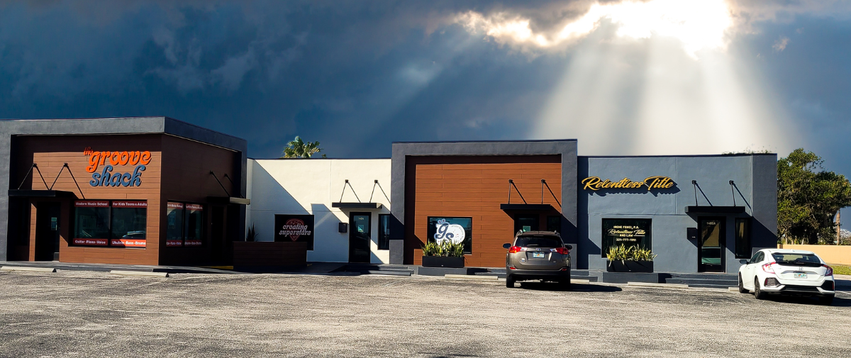 Exterior view of the Relentless Title office, with a stormy sky in the distance and sun shining on Relentless Title.