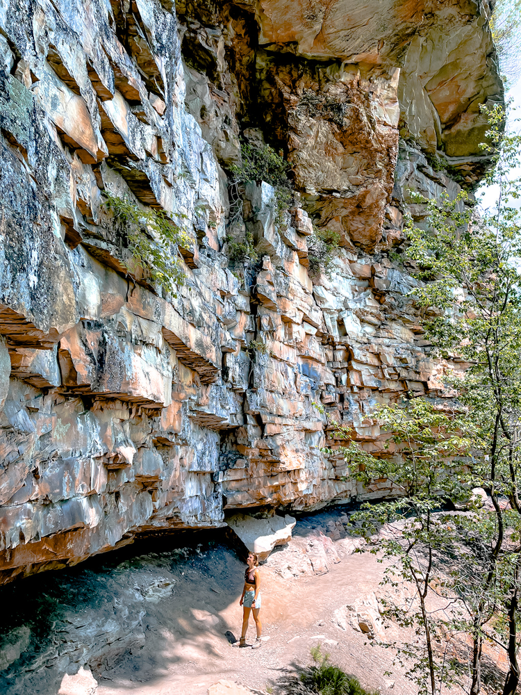 A girl standing next to towering rock formations
