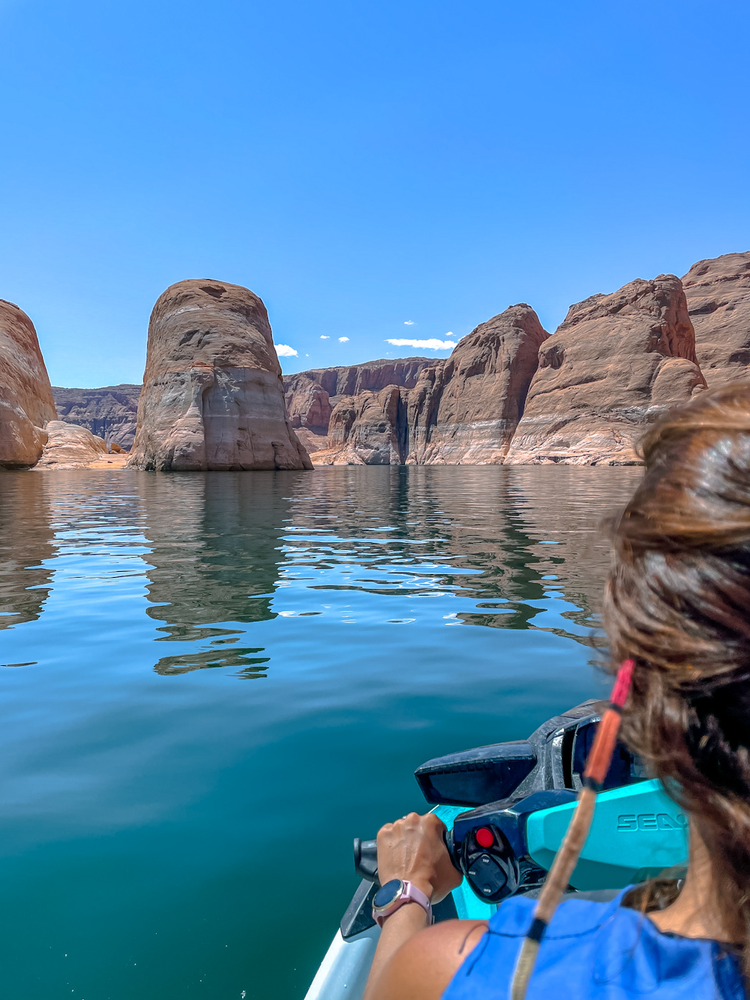 A woman can be seen driving a jet ski on the lake