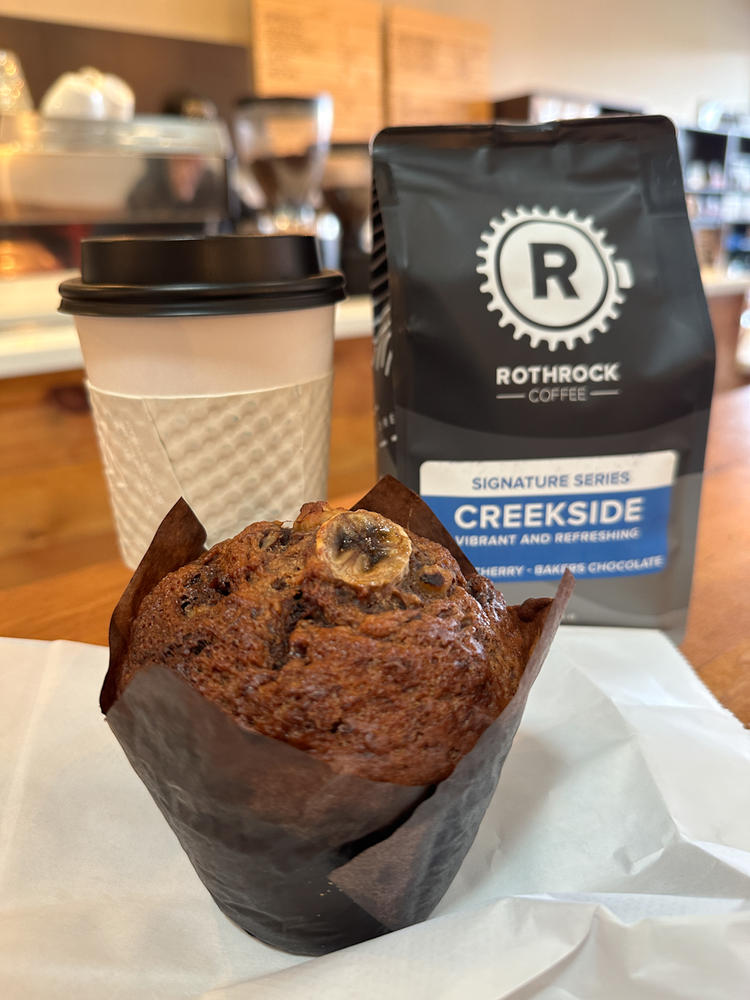 A muffin, a coffee cup and a bag of coffee