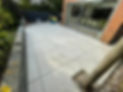 Newly laid patio tiles in a backyard with a view of the house
