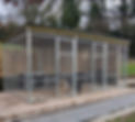 A spacious outdoor dog kennel with metal fencing and a roof