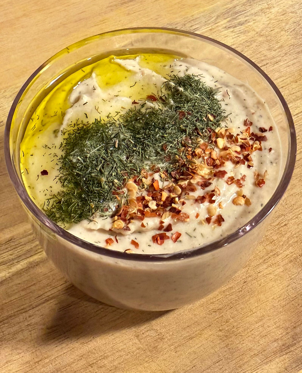 Close-up view of creamy butter bean hummus in a rustic bowl with olive oil drizzle