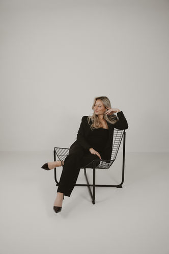 Elegantes Frauen-Porträt – Sitzende Pose im schwarzen Outfit für Business-Websites und LinkedIn.
