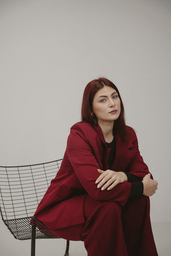 Modernes Business-Porträt – Frau sitzt entspannt auf einem Designerstuhl