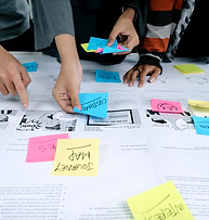 Close-up of hands arranging post-it notes during a technical training workshop
