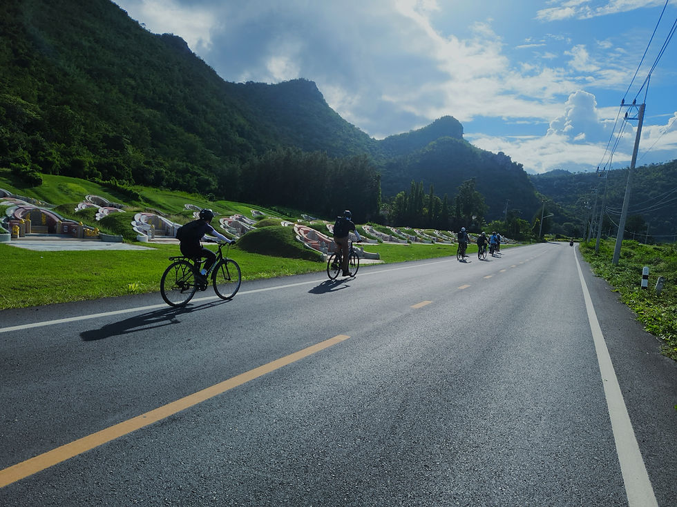 Cyclists enjoy Kanchanaburi outdoor activities on a scenic road.