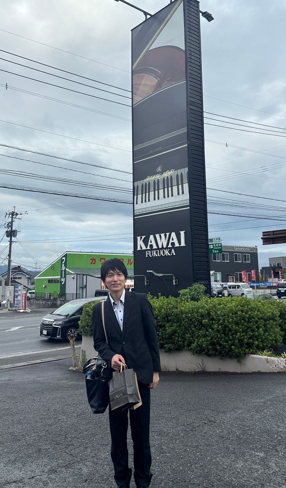 カワイ楽器の看板の前で PHOTO by 尾城先生