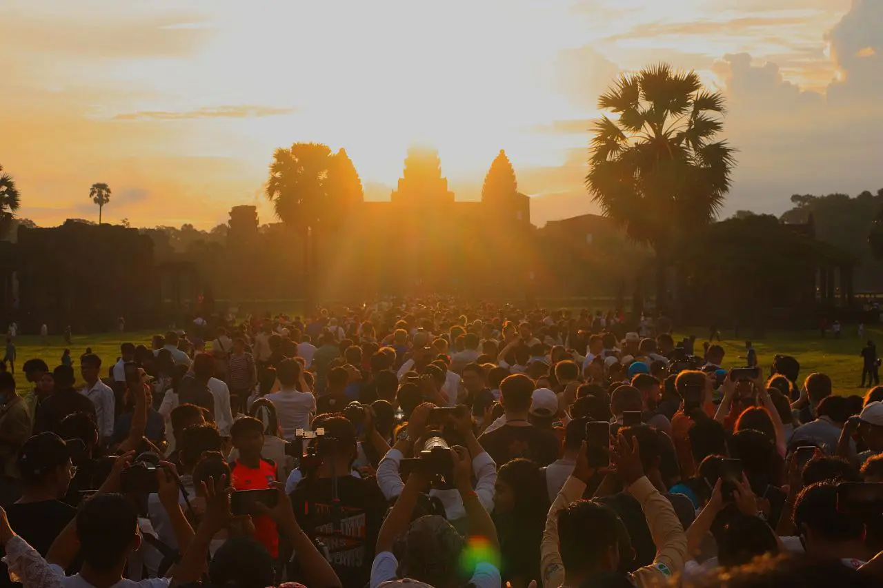 Les touristes viennent observer le lever du soleil sur le temple d'Angkor Wat.