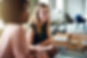 Two diverse female designers smiling while working together at a boardroom table during a 