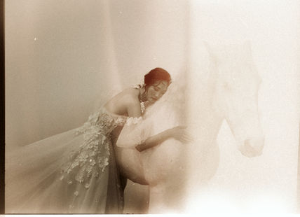 Dreamlike bridal portrait on film at Le Belvédère in Ottawa, featuring a bride embracing a white horse, captured by fine art wedding photographers Hastings & King.