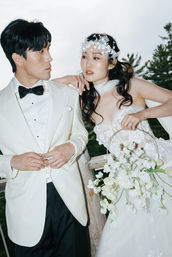 Editorial wedding portrait at Le Belvédère in Ottawa, featuring a fashion-forward bride with floral headpiece and groom in a white tuxedo, captured by fine art wedding photographers Hastings & King.