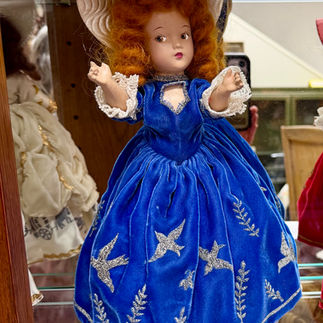 A 1947 Utah Centennial Day Doll wearing a royal blue gown decorated with wheat, crickets, and seagul