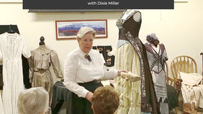 Dixie Miller holding a Victorian-era shoe while presenting on Victorian and pioneer fashions at the McQuarrie Memorial Pioneer Museum.