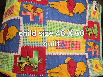 Handmade child-size Winnie the Pooh quilt displayed in the Pioneer Museum Gift Shop.