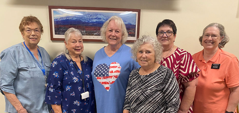 Group photo of the six volunteer staff members of the McQuarrie Memorial Museum standing together inside the museum.