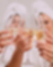 A group of women spend leisure time. Young attractive females in bathrobes drink champagne