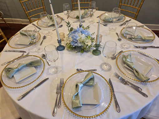 Luxury event table styled with greenery, candles, and modern place settings