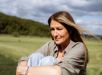 Frau sitzt nachdenklich in der Natur – symbolisiert innere Reflexion, Ruhe und achtsame Coaching-Atmosphäre