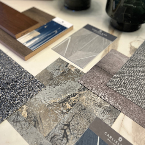 Luxury interior design material board featuring marble-look surfaces, wood finishes, and textured fabric samples by J. Lynn Design Group Naple