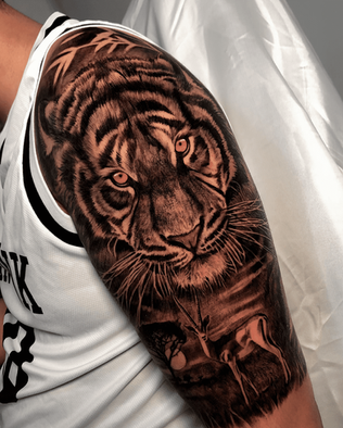 Tattoo of a gazelle and a tiger on upper arm in Black and White Realism by APZ in Copenhagen, Denmark.In Copenhagen, APZ is a skilled tattoo artist trained by some of the best tattoo artists in the world. He specializes in classic realism tattoos using a modern black and white style, focusing on connected designs and full sleeve tattoos that enhance his clients’ style. His gazelle and tiger tattoo on upper arm speaks volumes with lifelike realistic details.