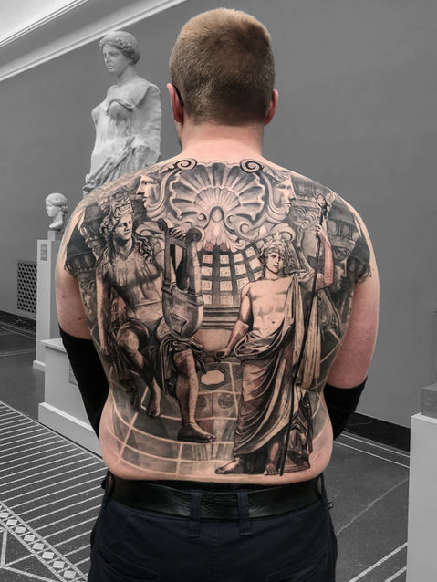 Tattoo of statue of Apollo and Dionysus on Back in black and white realism by APZ in New York, USIn New York, APZ is a skilled tattoo artist trained by some of the best tattoo artists in the world. He specializes in classic realism tattoos using a modern black and white style, focusing on connected designs and full sleeve tattoos that enhance his clients’ style. His statue Apollo and Dionysus tattoo on back speaks volumes with lifelike realistic details.