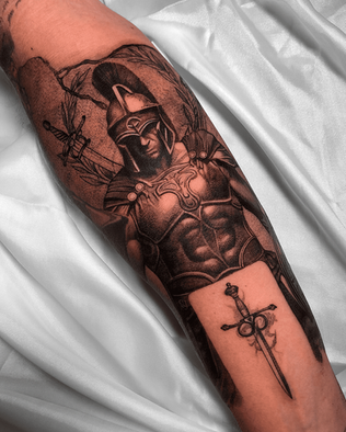 Tattoo of Roman Soldier on forearm in Black and White Realism by APZ in Copenhagen, Denmark.In Copenhagen, APZ is a skilled tattoo artist trained by some of the best tattoo artists in the world. He specializes in classic realism tattoos using a modern black and white style, focusing on connected designs and full sleeve tattoos that enhance his clients’ style. His Roman Soldier tattoo on forearm speaks volumes with lifelike realistic details.