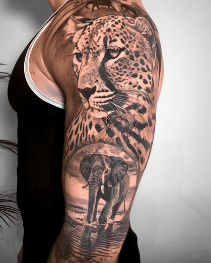 Tattoo of a cheetah and a elephant on upper arm in Black and White Realism by APZ in New York, US.In New York, APZ is a skilled tattoo artist trained by some of the best tattoo artists in the world. He specializes in classic realism tattoos using a modern black and white style, focusing on connected designs and full sleeve tattoos that enhance his clients’ style. His cheetah and a elephant tattoo on upper arm speaks volumes with lifelike realistic details.