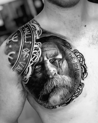 Tattoo of statue Odin on chest in Black and White Realism by APZ in Copenhagen, Denmark.In Copenhagen, APZ is a skilled tattoo artist trained by some of the best tattoo artists in the world. He specializes in classic realism tattoos using a modern black and white style, focusing on connected designs and full sleeve tattoos that enhance his clients’ style. His sculpture Odin tattoo on chest speaks volumes with lifelike realistic details.