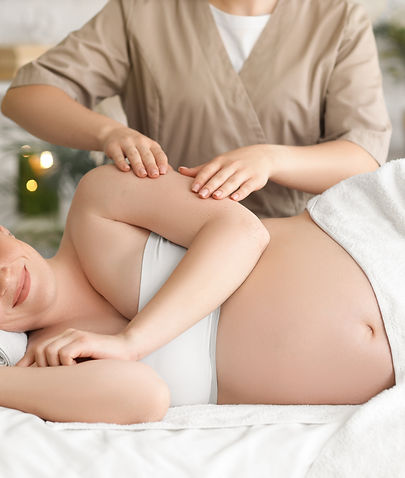 Young pregnant woman getting arm massage in spa salon.jpg