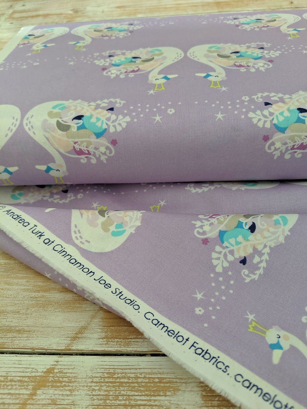 Thumbnail: Camelot Fabric, Andrea Turk of Cinnamon Joe Studio, Fabric swans on lavender background.