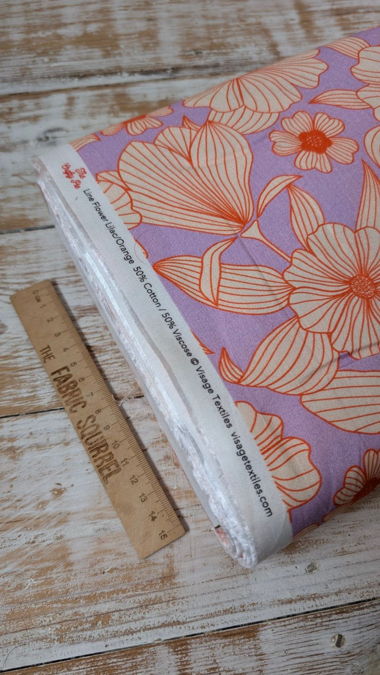 Thumbnail: Fabric roll with orange and white text, 50% Cotton, Purple Floral Fabric. The Fabric Squirrel.