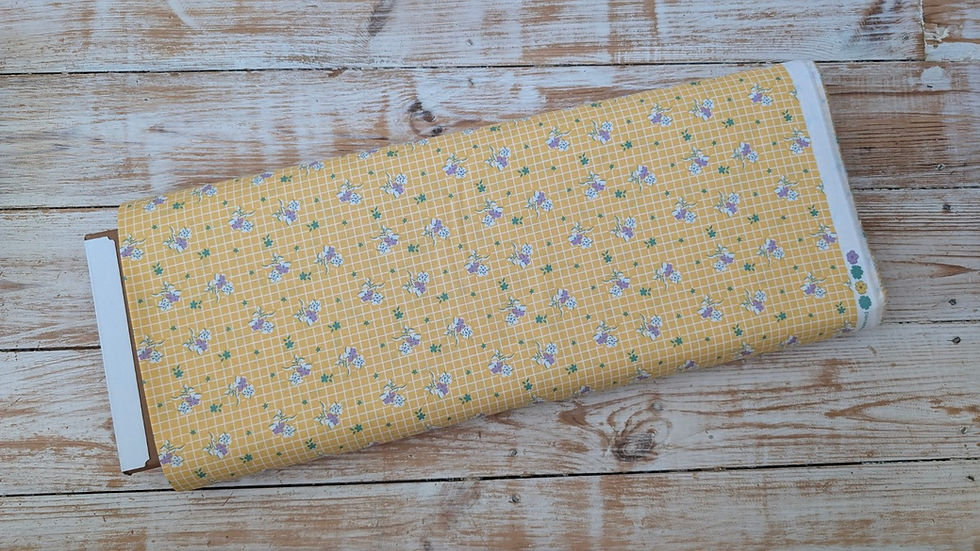 Thumbnail: Yellow fabric with small floral pattern displayed on a wooden surface.