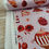 Thumbnail: Red patterned fabric roll with assorted illustrations, Jennie's Reds collection