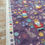 Thumbnail: Purple fabric with flower and gnome pattern. Golden Key Fabric - The Secret Winter Garden.