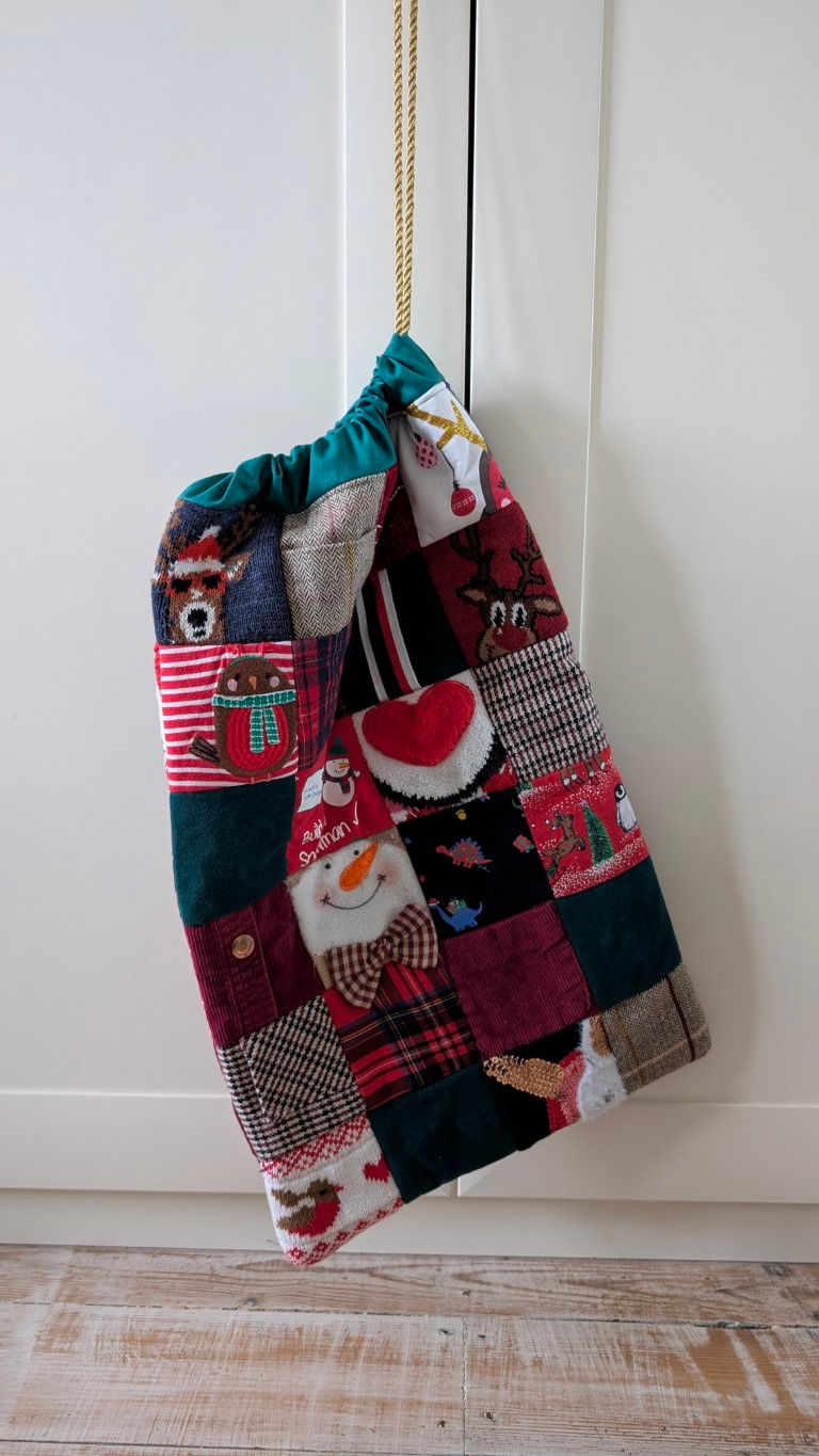 Thumbnail: Quilted Christmas sack with various festive patches, Extra Large Keepsake Christmas Gift Sack, hanging.