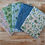 Thumbnail: Various floral fabric swatches on wood; Twilight Caps Fabric - Nightfall Forest | Craft Cotton Co.