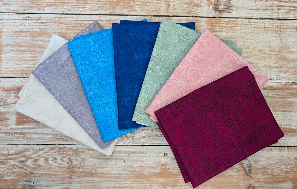 Thumbnail: Variety of colorful linen napkins fanned out on a wooden table.