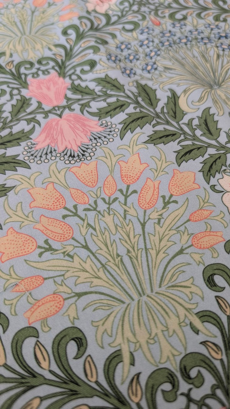 Thumbnail: Floral fabric with pink and orange flowers and stylized green leaves pattern.