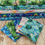 Thumbnail: Stacked fabric rolls with tropical themes: palm trees, turtles, and watercolor designs.