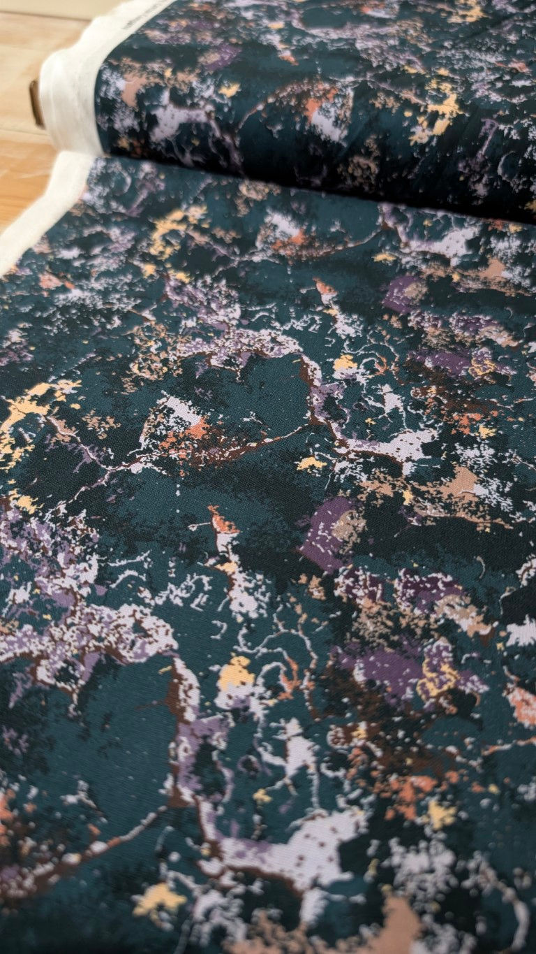 Thumbnail: Dark green fabric with light patches. Pink Stretch Costume Fabric - Spandex and Nylon Blend Material.