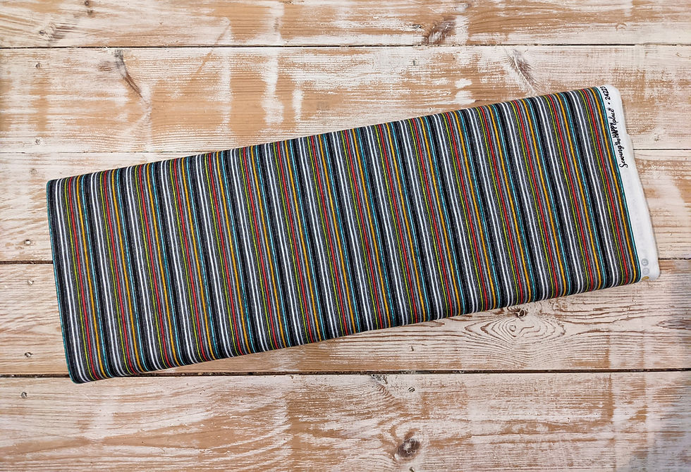 Thumbnail: Fabric roll with gray, orange, and blue stripes on a wooden surface.