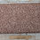 Thumbnail: Brown fabric with small, repeating pattern on a wooden surface.