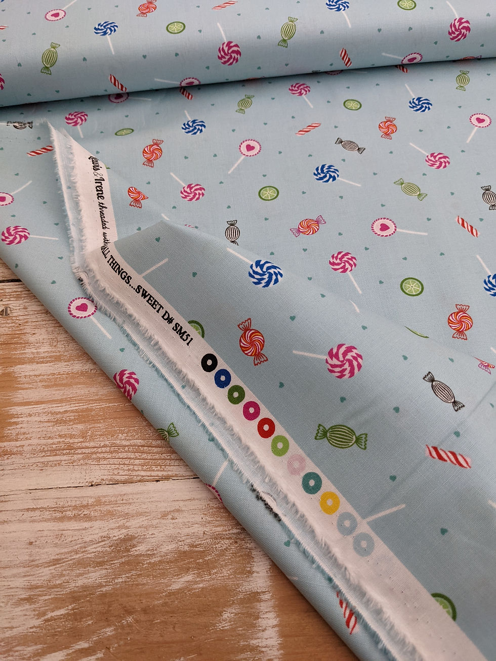 Thumbnail: Light blue fabric printed with candy pattern, Sweet on Earth text visible.