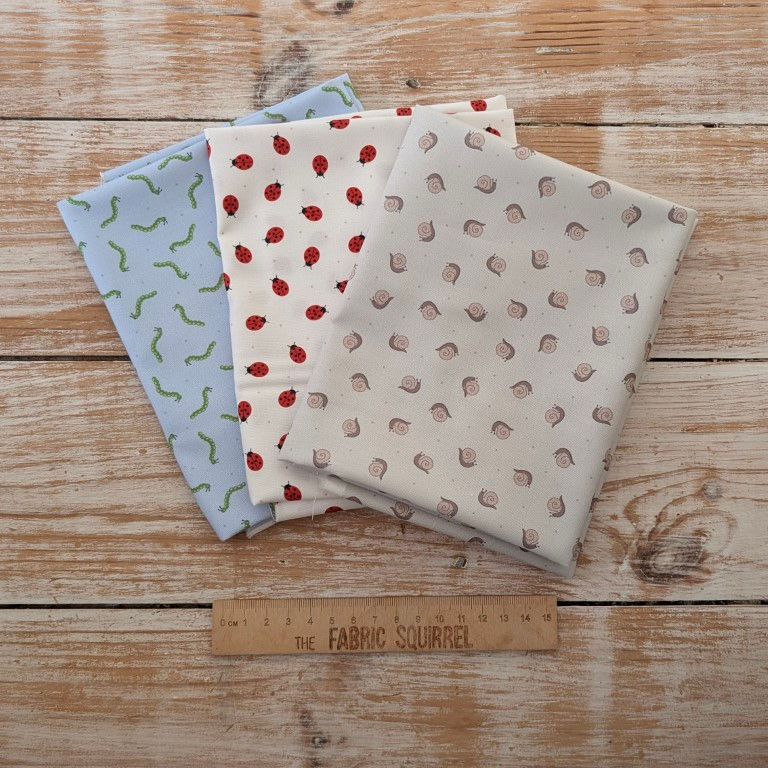 Thumbnail: Three fabric squares on wood surface with different patterns Haberdashery Fabric on Orange.