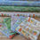 Thumbnail: Stacked fabric rolls and folded fat quarters with floral and plant patterns, The Fabric Squirrel.