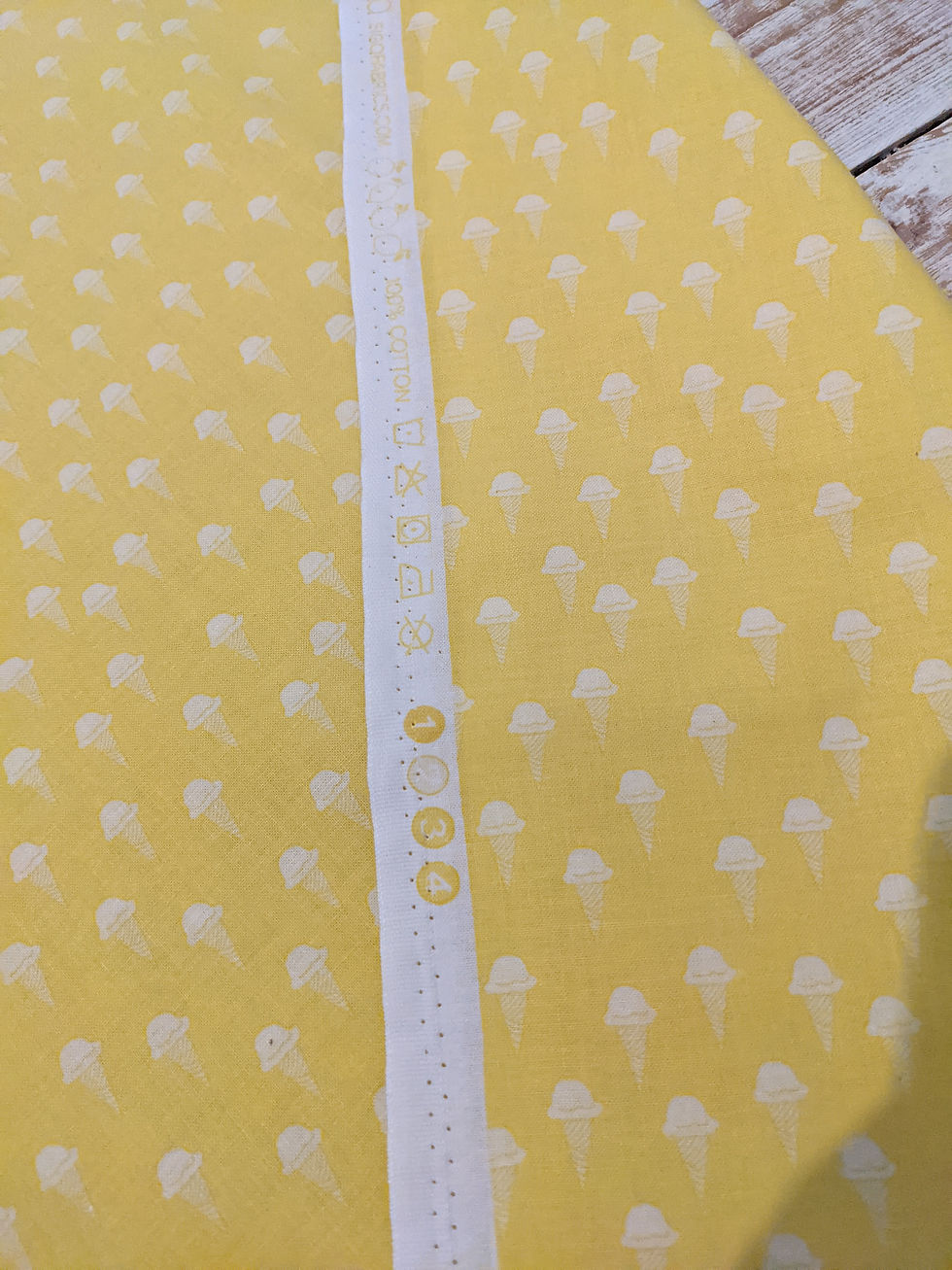 Thumbnail: Yellow patterned fabric with a white strip and small circle pattern.